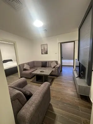 a living room with two couches and a tv at central apartment for rent 19 in Umm Uthainah