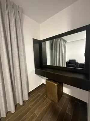 a living room with a mirror and a curtain at central apartment for rent 19 in Umm Uthainah
