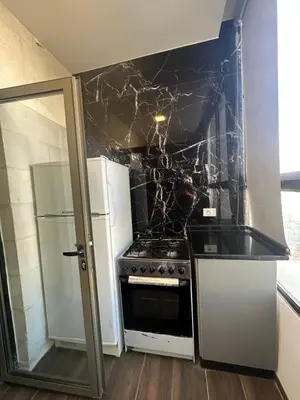 a kitchen with a stove and a refrigerator at central apartment for rent 19 in Umm Uthainah