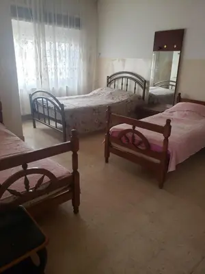 a bedroom with three beds and a mirror in it at Alotaibi #6 in Amman