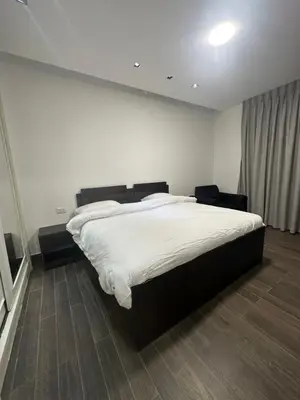 a bedroom with a large bed with white sheets at central apartment for rent 20 in Amman