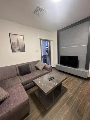 a living room with a couch and a flat screen tv at central apartment for rent 20 in Amman