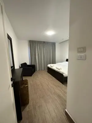 a small hotel room with a bed and a chair at central apartment for rent 21 in Amman