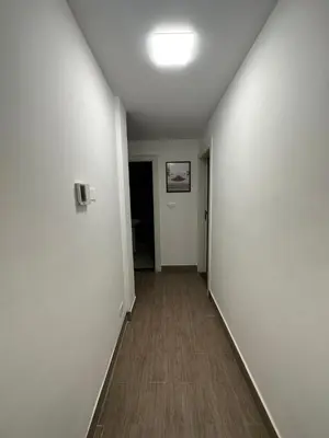 an empty hallway with white walls and a wooden floor at central apartment for rent 22 in Amman