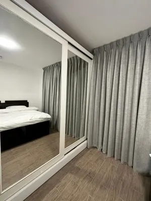 a bedroom with a bed and a large window at central apartment for rent 22 in Amman