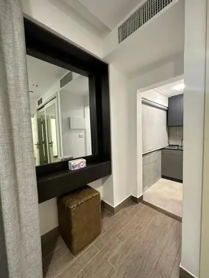 a bathroom with a large mirror and a stool at central apartment for rent 23 in Umm Uthainah