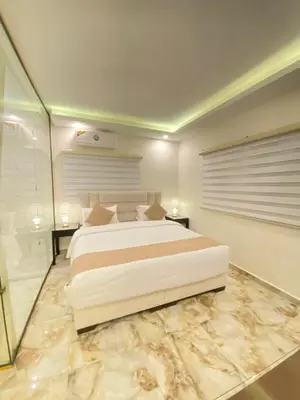 a bedroom with a large white bed and a shower at Eighth Wonders Hotel in Wadi Musa