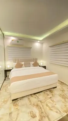 a bedroom with a large white bed and two tables at Eighth Wonders Hotel in Wadi Musa