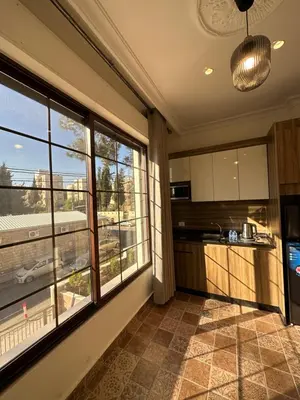 a kitchen with large windows and a view of a street at 9 Antica jabalal-lwebdeh in Amman