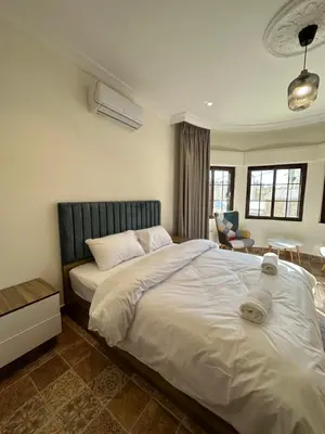 a bedroom with a large white bed and a chair at 10 Antica jabalal-lwebdeh in Amman