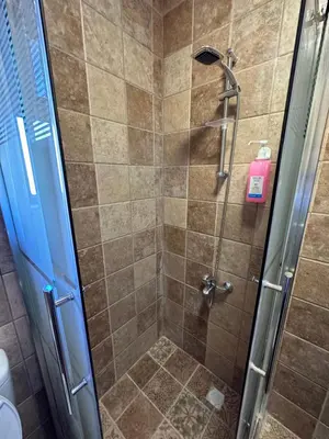 a shower stall with a glass door and a shower at 11 Antica jabalal-lwebdeh in Amman