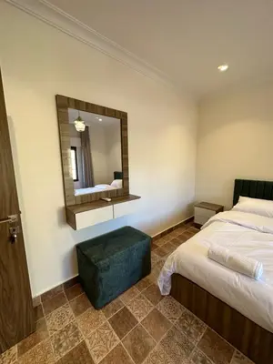 a hotel room with two beds and a mirror at 12 Antica jabalal-lwebdeh in Amman