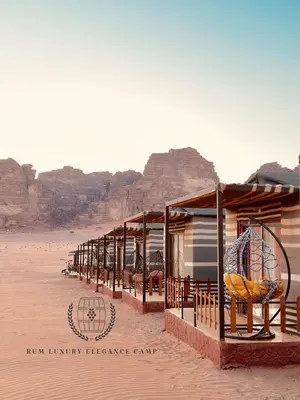 a row of houses in the desert with mountains in the background at RUM lUXURY ELEGANCE CAMP in Wadi Rum