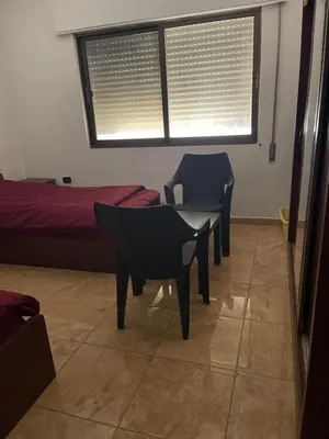 a room with two chairs and a bed and a window at Samar Home in Amman
