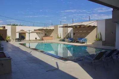 a swimming pool with chairs and tables and a building at Florya Villa by Seahorse in Amman