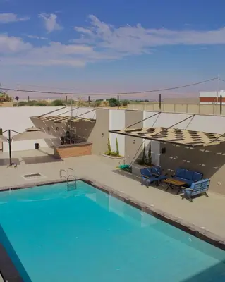a swimming pool with chairs and a house at Florya Villa by Seahorse in Amman