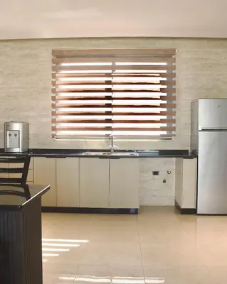 a kitchen with a refrigerator and a large window at Florya Villa by Seahorse in Amman