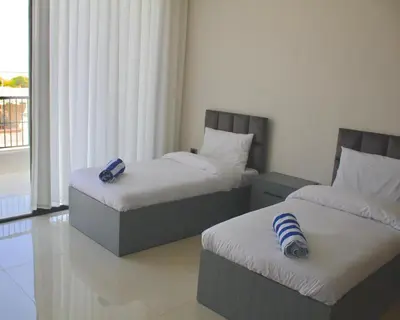 two beds in a room with a window at Florya Villa by Seahorse in Amman