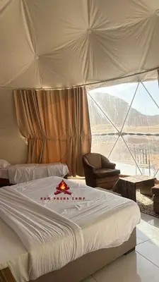 a hotel room with a bed and a large window at Rum prens camp in Wadi Rum