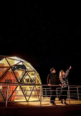 two people standing on a fence in front of a theatre at Rum prens camp in Wadi Rum