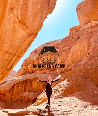 a woman standing in the desert in front of a canyon at Rum prens camp in Wadi Rum