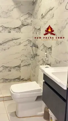 a bathroom with a white toilet and a sink at Rum prens camp in Wadi Rum