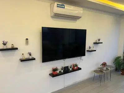a flat screen tv hanging on a wall at Rosario Farm Home in Amman