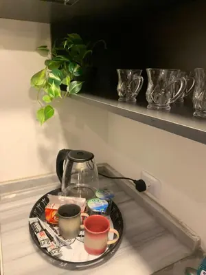 a tray with a tea kettle and cups on a shelf at Rosario Farm Home in Amman