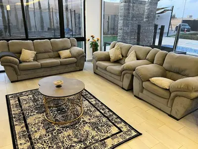 a living room with two couches and a coffee table at Rosario Farm Home in Amman
