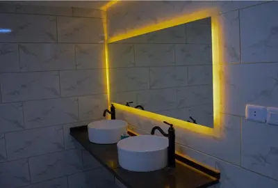 a bathroom with two sinks on a counter with lights at Rosario Farm Home in Amman
