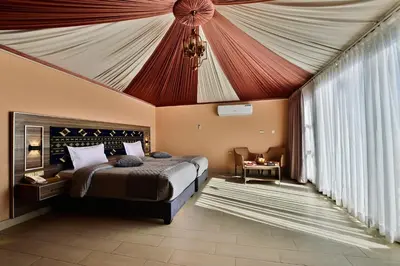 a bedroom with a bed with a tent ceiling at Mars Land Luxury Camp in Wadi Rum