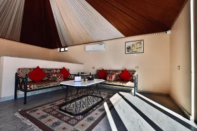 a living room with red pillows and a table at Mars Land Luxury Camp in Wadi Rum
