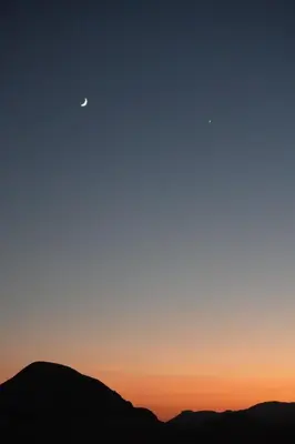 a view of the sunset with the moon andupiter at Bedouin cave wadi rum campsite in Wadi Rum