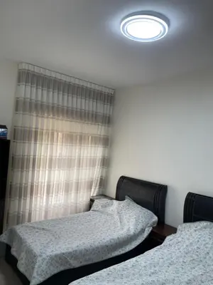 a bedroom with two twin beds and a light at Charming modern 2BD in Abdoun in Amman