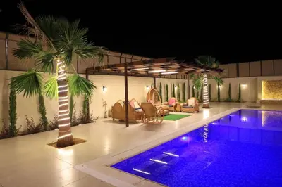 a house with a swimming pool and a palm tree at Sunrise Villa in Sowayma