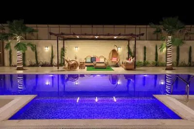 a pool with purple lights in a resort at night at Sunrise Villa in Sowayma