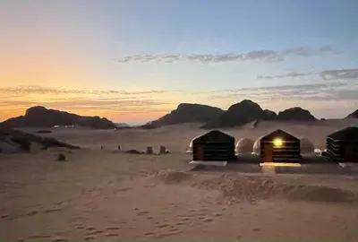 a group of huts in the desert at sunset at Ahmad and Fatima's Traditional Bedouin Camp in Wadi Rum