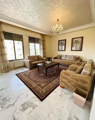 a large living room with couches and a table at Furnished Apartment for Rent in Abdoun 200sqm in Amman
