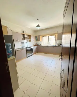 a large kitchen with a large white tile floor at Furnished Apartment for Rent in Abdoun 200sqm in Amman