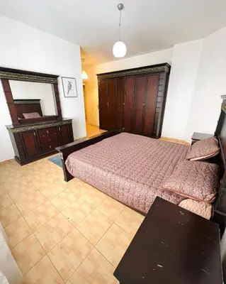 a bedroom with a bed and a dresser and a mirror at Furnished Apartment for Rent in Abdoun 200sqm in Amman