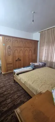 a bedroom with two beds and wooden cabinets at Nights of the Orient Guesthouse in Al Salt