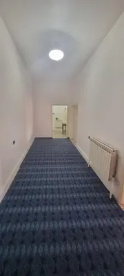 an empty room with a carpeted floor in a building at Nights of the Orient Guesthouse in Al Salt