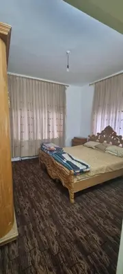a bedroom with a bed in a room with curtains at Nights of the Orient Guesthouse in Al Salt