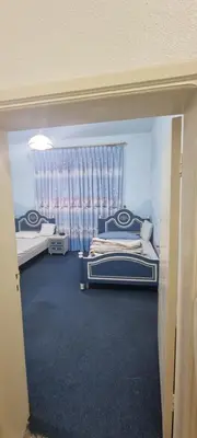 a bedroom with two beds and a window at Nights of the Orient Guesthouse in Al Salt