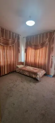 a bedroom with curtains and a bed in a room at Nights of the Orient Guesthouse in Al Salt