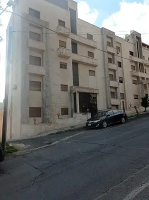 a black car parked in front of a building at Cozy apt Grt location for long and short stay in Amman