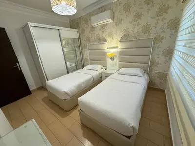a bedroom with two beds and a mirror at Cozy apt Grt location for long and short stay in Amman