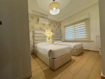 a bedroom with two beds and a window at Cozy apt Grt location for long and short stay in Amman