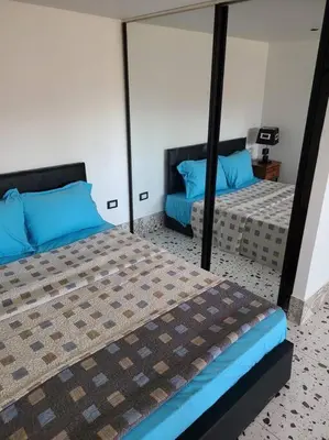 a bedroom with two beds with blue pillows and a mirror at Loft Apartment Jabal Amman B in Amman
