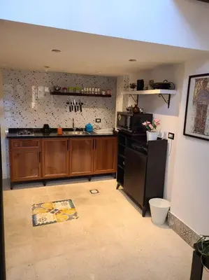 a kitchen with wooden cabinets and a black refrigerator at Loft Apartment Jabal Amman B in Amman